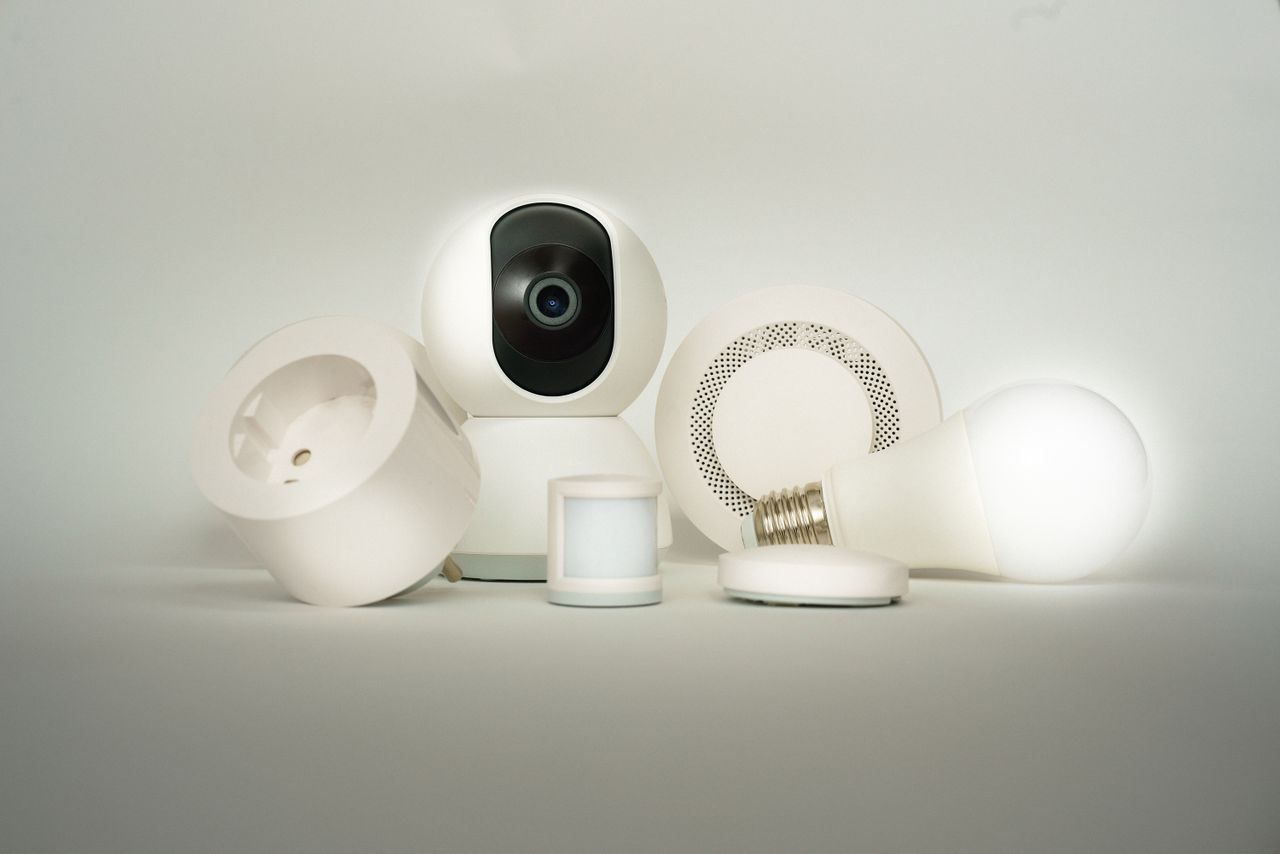 services-03 A collection of smart home devices, including a camera, light bulb, and sensors, on display.
